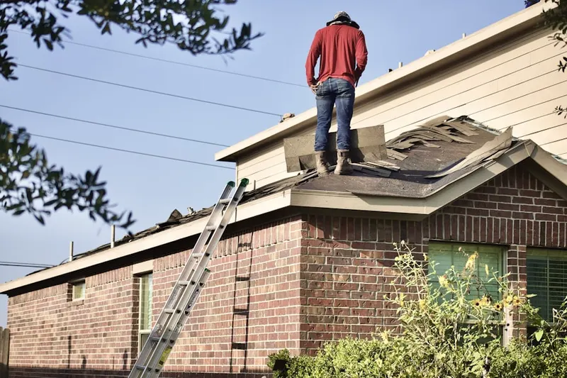 Professional roofer working on a residential roof in Delgado